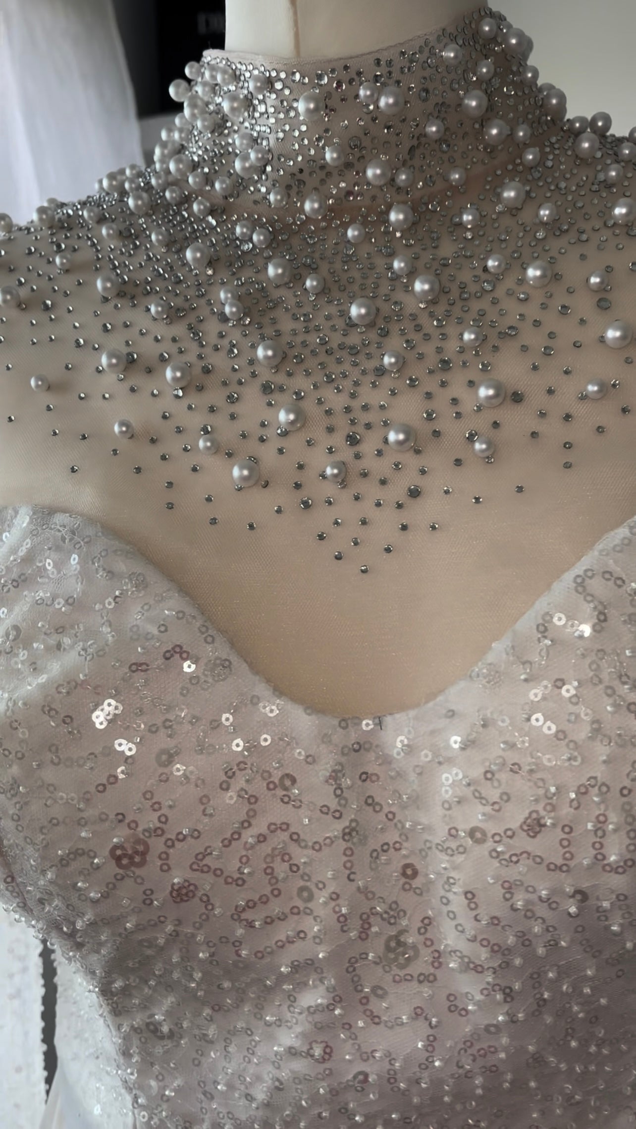 Weißes Kleid mit asymmetrischem Schnitt und Perlenkragen