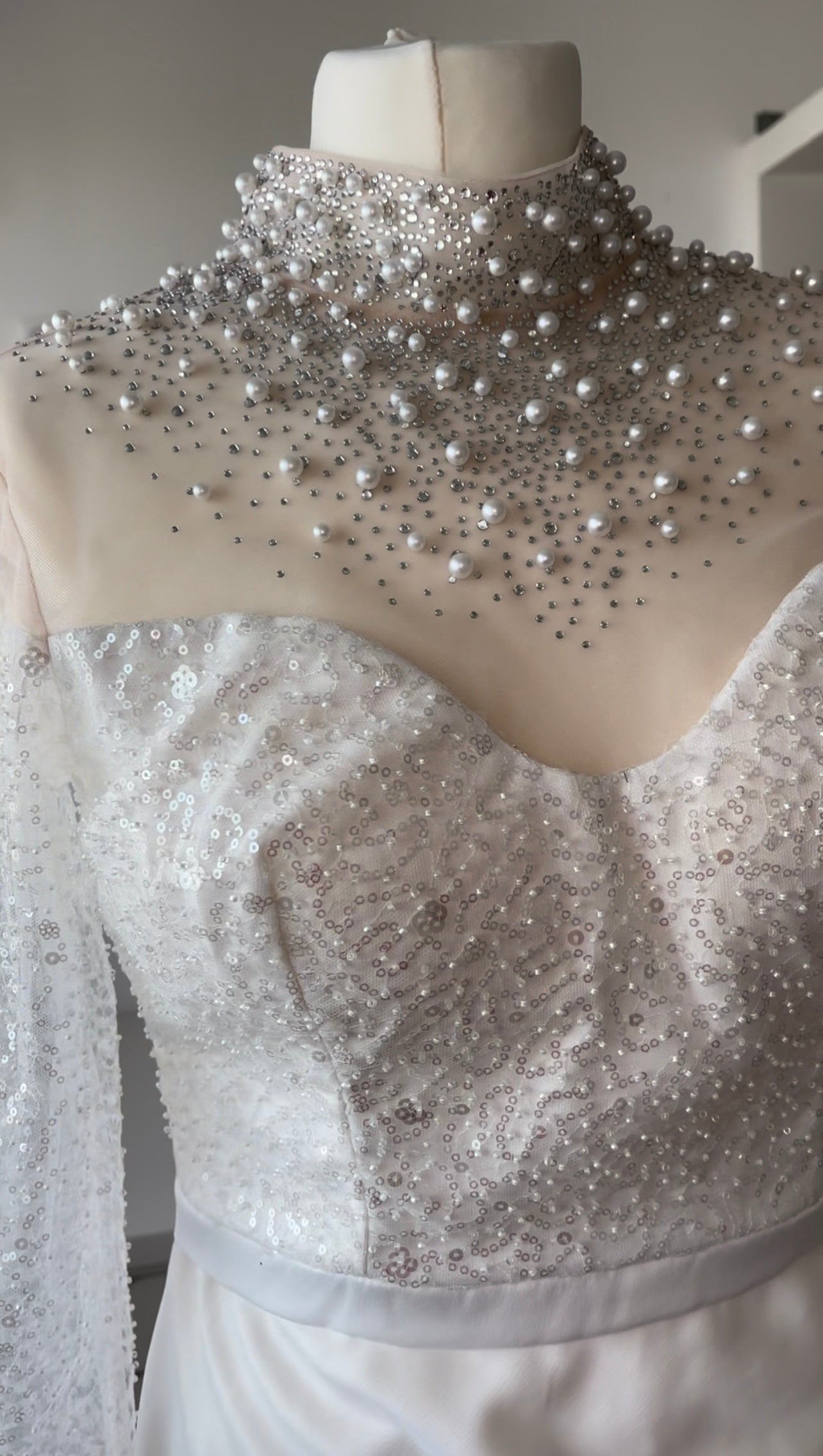 Weißes Kleid mit asymmetrischem Schnitt und Perlenkragen